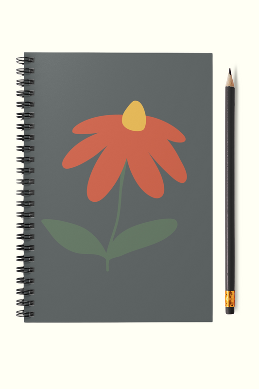 Notebook with a red flower design on a gray background, accompanied by a pencil.