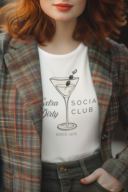 Woman wearing a retro white martini themed t-shirt with a cocktail graphic and text, paired with a plaid jacket.