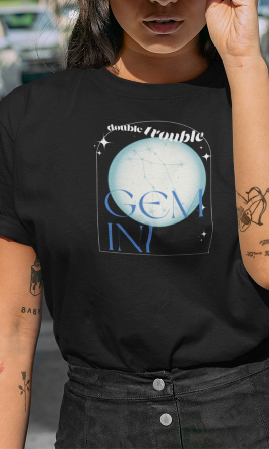 Person wearing a black t-shirt with 'Gemini' design, standing outdoors.