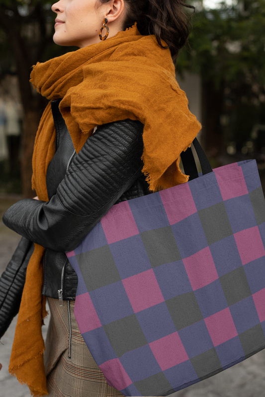 Person wearing a mustard yellow scarf and holding a checkered bag outdoors