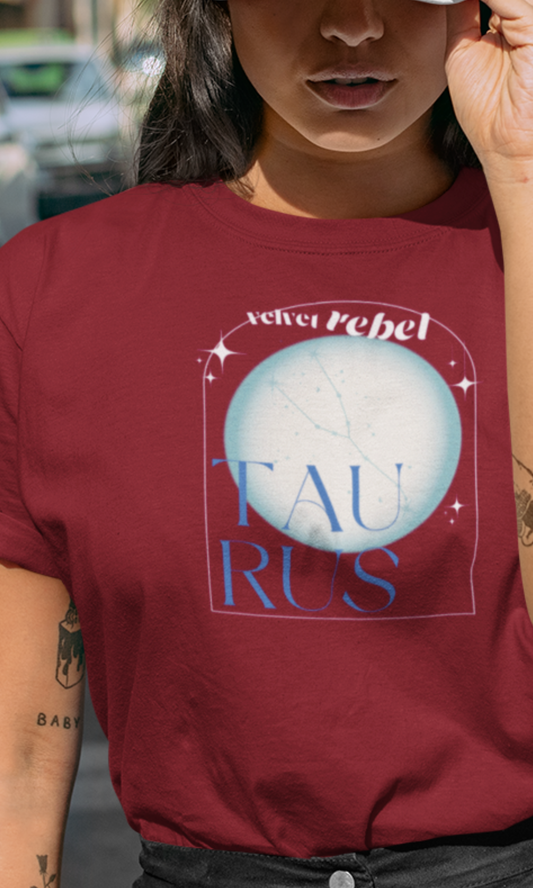 woman wearing a red t-shirt with 'velver Rebel Taurus' design outdoors.
